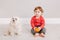 Cute adorable Caucasian baby boy eating citrus fruit. Finny child sitting with pets dogs and eating healthy organic snack. Solid