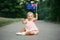 Cute adorable Caucasian baby girl waving Australian flag. Smiling child sitting on street road in park celebrating Australia Day