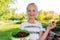 Cute adorable caucasian blond litlle school girl enjoy eating healthy ripe tasty juicy dark red cherry in green bowl at