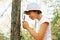 Cute adorable Caucasian girl kid looking at tree in forest through magnifying glass.