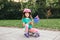 Cute adorable Caucasian girl in pink helmet sitting on skateboard waving Australian flag. Smiling sporty young child sitting on