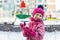 Cute adorable caucasian little girl winter portrait holding snowball in hands ready for snow fight at playground outdoor. Funny