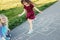 Cute adorable children girls friends playing jumping hopscotch outdoors. Funny activity game for kids on playground outside.