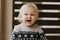 Cute Adorable Little Blonde Toddler Kid Laughing, Having Fun, and Making Silly Faces Outside at Home on the Patio Screened Porch