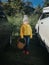 cute adorable little Caucasian girl in yellow jacket and warm grey hat. Child on farm with wicker basket going to pick fresh apple