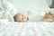 Cute adorable newborn baby boy wrapped or swaddle in a blanket, sleeping and sometime both eyes open in kids bed