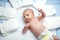 Cute adorable newborn baby on changing table with diapers. Cute little girl or boy looking at the camera. Dry and