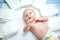 Cute adorable newborn baby on changing table with diapers. Cute little girl or boy looking at the camera. Dry and