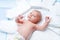 Cute adorable newborn baby on changing table with diapers. Cute little girl or boy looking at the camera. Dry and