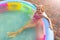 Cute adorable playful caucasian blond kid girl enjoy having fun swimming and relaxing in small inflatable pool at house
