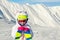Cute adorable preschooler caucasian kid girl portrait with ski in helmet, goggles and unicorn fun costume enjoy winter sport