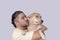 Cute and adorable scene of a man kissing his spoiled mid-sized adult dog he is carrying on his shoulders. Isolated on a white