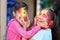 Cute adorable siblings playing with colours during holi festival of colors Indian asian caucasian creative portrait