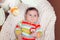 Cute adorable smiling white Caucasian baby boy girl lying in bouncer chair.