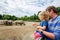 Cute adorable toddler girl and father watching wild rhinos in zoo. Happy baby child, daughter and dad, family having fun