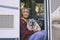 Cute adult woman sitting and relaxing on the door of her camper van with her two pug dogs. Best friends and friendship concept.