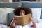 Cute African American girl reading in bed