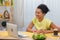 Cute African American woman talking by video call on a laptop. A young woman demonstrates a painted egg and Easter cake