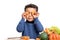 Cute afro american boy playing with carrot slices.