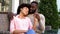 Cute afro-american couple relaxing in outdoor cafe, hugging and talking, love