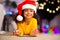 Cute afro girl in Santa hat drawing on floor at home