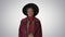 Cute afro model in coat touching hat walking on gradient background.