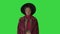 Cute afro model in coat touching hat walking on a Green Screen, Chroma Key.
