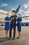 Cute airline captain and air hostesses standing at the airdrome