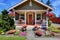 Cute American house exterior with covered porch and flower pots