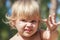 Cute angry Caucasian blond baby girl portrait