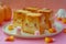 Cute Animated Toast Characters on Plate with Halloween Candy Corn and Decorations on Pink Background