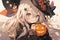 cute anime girl with long white hair holding carved pumpkin for halloween