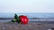 Cute artificial rose lies on sand against running waves