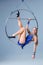 Cute artistic gymnast exercising with hanging hoop