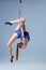 Cute artistic gymnast exercising with hanging hoop