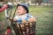 Cute asian baby sitting in bicycle basket,vintage tone