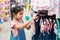 Cute asian child girl choosing dresses in clothes department