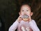 Cute Asian child girl enjoy eating rainbow donut
