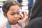 Cute asian child girl getting face painted