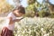 Cute asian child girl looking beautiful flower through a magnify