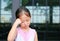Cute Asian child girl posture her hand on head with little smile
