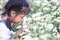 Cute asian child girl sniffing beautiful flower