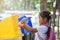 Cute asian child girl throwing plastic glass in recycling trash