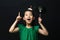 cute asian girl child dressed in a green dress holding an idea bulb stick with a christmas head decoration on a black background.