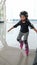 Cute Asian girl child learning how to keep balance on roller skate. Sport outdoor activity for kid