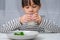 Cute Asian girl drinking a glass of milk in the morning before going to school. Little girl eats healthy vegetables and milk for