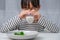 Cute Asian girl drinking a glass of milk in the morning before going to school. Little girl eats healthy vegetables and milk for