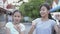 Cute asian girl and her sister enjoy to practice lovely dance during standing on the pathway in a housing estate.