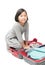 cute asian girl packing suitcases preparing for travel trip isolated