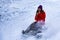 Cute Asian girl is riding a sledge on a high speed